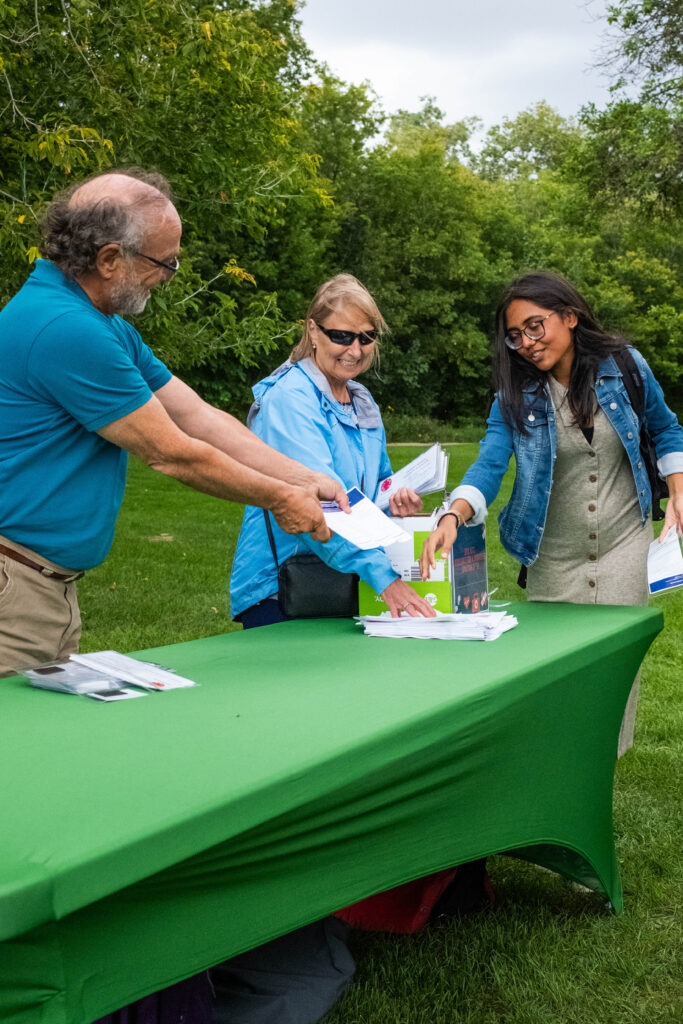 A Summer Internship Program participant works with two volunteers at a presentation in Assiniboine Park.
