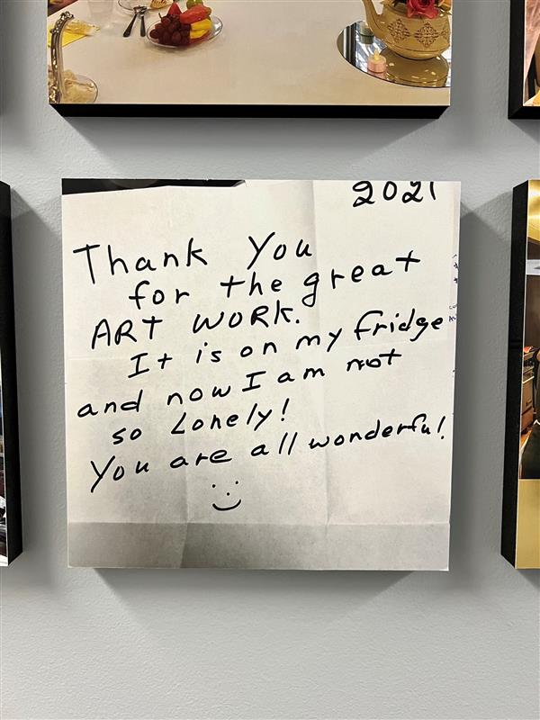 A tile featuring a note that reads "Thank you for the great art work. It is on my fridge and now I am not so lonely. You are all wonderful!"