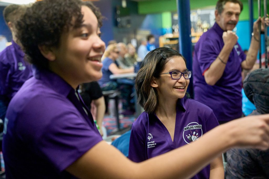 Special Olympics Manitoba athletes smile and socialize during bowling practice.