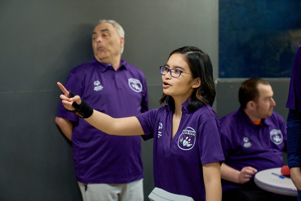 Elizabeth Dela Cruz points toward the bowling lanes during a Special Olympics event.
