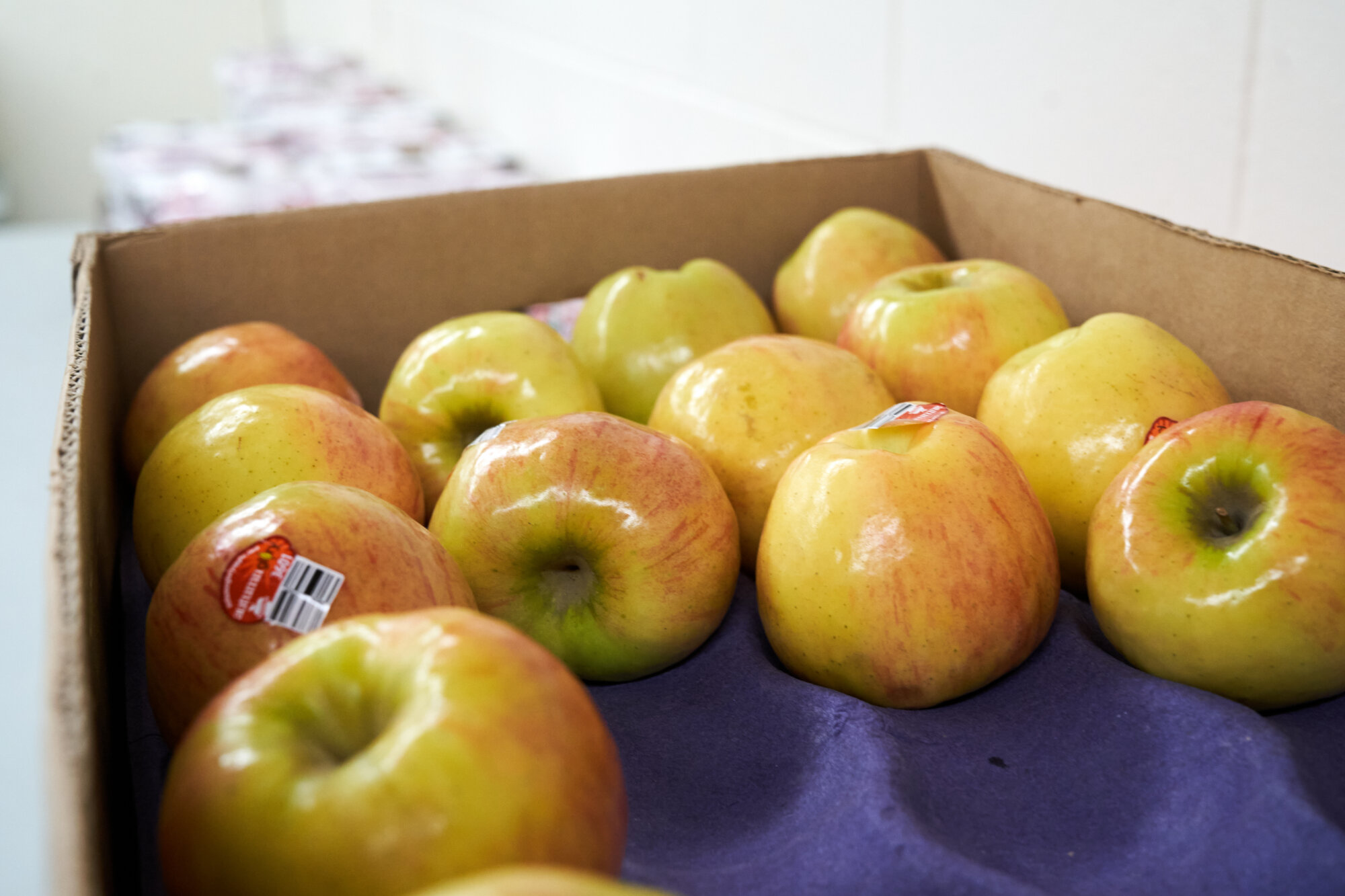 Apples sitting in crate.