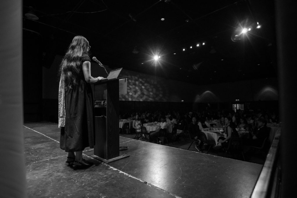 Divya Sharma, Youth in Philanthropy Alumna speaking to a crowd of students.